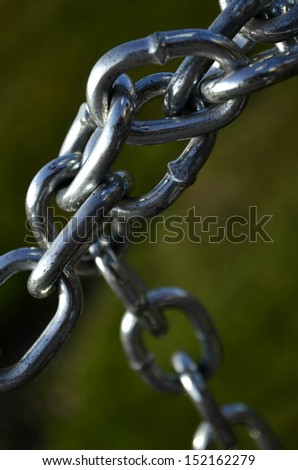 Detail of silver chain links on green background