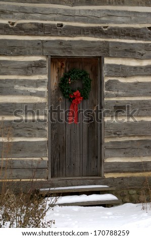 Christmas wreath on the door of an historic log cabin