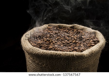 Sack full of still hot, freshly roasted coffee beans with the smoke rising in the air.