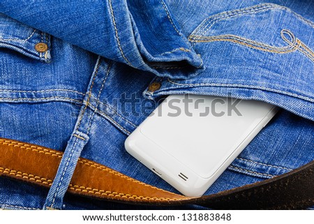 White mobile phone in back pocket of blue jeans