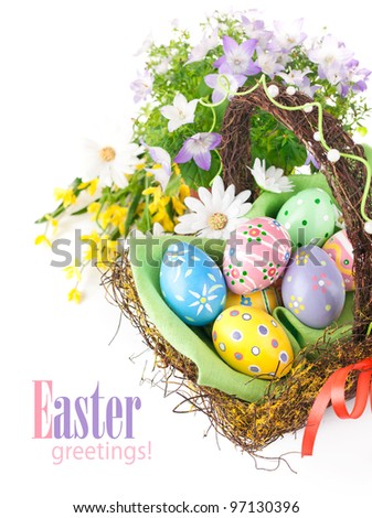 easter eggs in basket with spring flowers isolated on white background