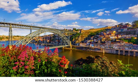 Porto, Portugal. Evening sunset picturesque view at old town with antique houses and red roofs near bridge Ponte de Dom Luis on river Douro. Stock foto © 