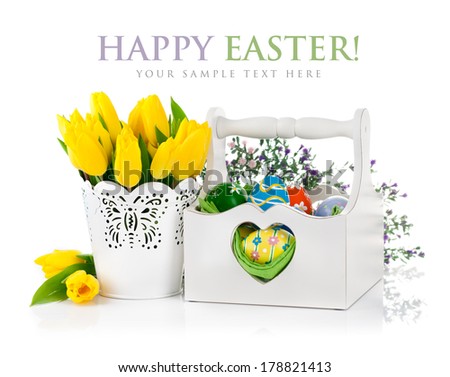 Easter eggs in basket with spring flowers. Isolated on white background