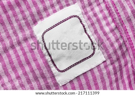 White blank label on pink striped cloth as a background