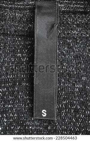 Black size label on black cloth as a background