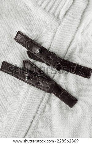 White knitted cloth with brown leather straps closeup