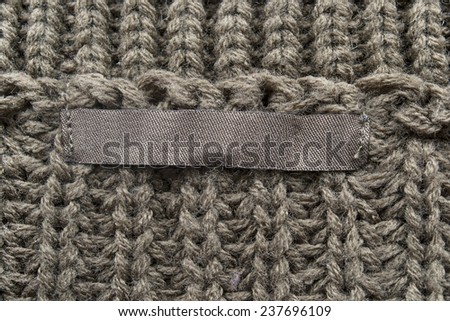 Blank label on brown knitted cloth as a background