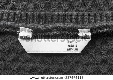 Black knitted cloth with white S size label as a background