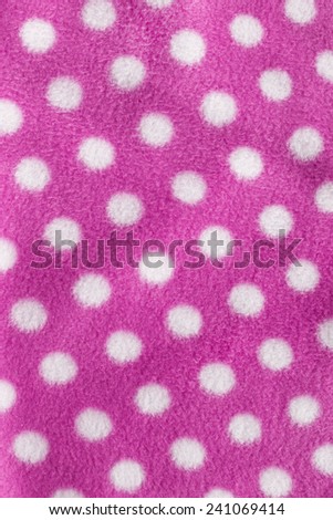 Pink fleece cloth with white polka dots as a background