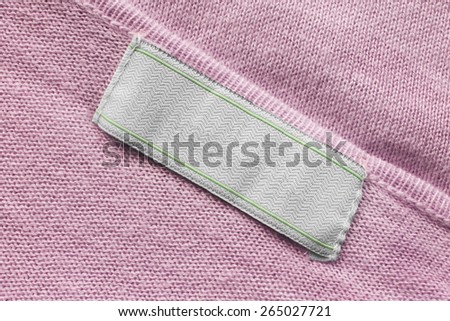 Blank white label on pink knitted cloth as a background