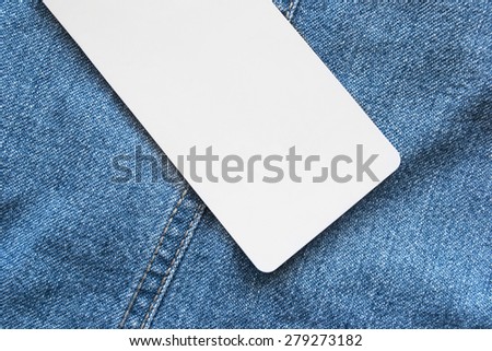Blank white label on blue denim as a background