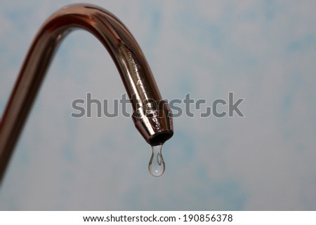 kitchen tap with water drops on a light-blue background