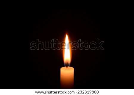 White candle burning on a black background