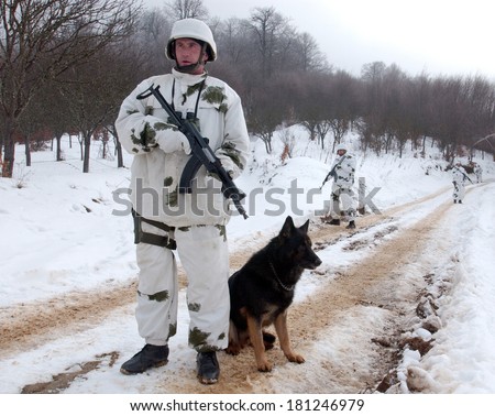 MEDVEDJA, SERBIA - CIRCA JANUARY 2008: Serbian border policeman with dog controls administrative border line with Kosovo, circa January 2008 in Medvedja