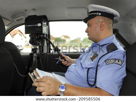 ZRENJANIN, SERBIA - CIRCA AUGUST 2014: Police officer controls driving speed at local road, circa August 2014 in Zrenjanin