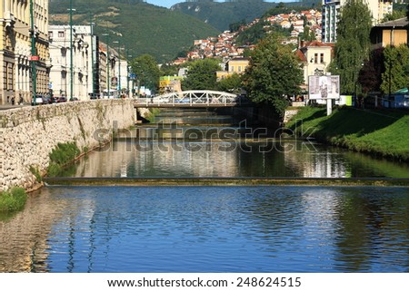SARAJEVO - BOSNIA AND HERZEGOVINA - AUGUST 28 , 2014 : Miljacka river and famous Cobanija bridge in center of Sarajevo near the Academy of fine art