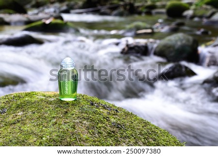 Spa shampoo on moss stone with waterfall background.