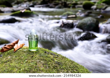 Spa shampoo on moss stone with waterfall background.