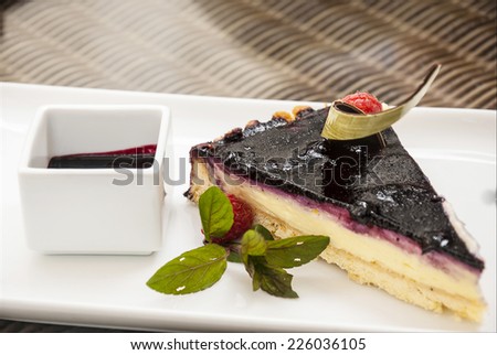 Cheesecake with blueberry and blackberry/Detail of cold fresh cheesecake with blueberry and blackberry served on white plate in restaurant