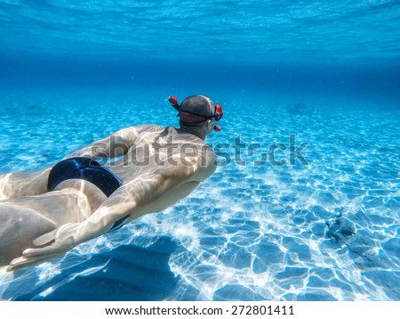 Young adult man swimming in depth of tropical sea water/Man swimming underwater