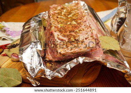 Fresh pork ribs, meat marinated and prepared for roast with garlic in a foil