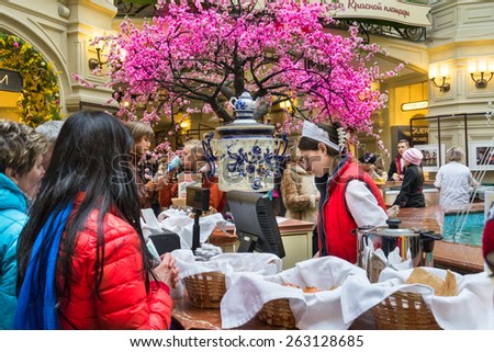 MOSCOW - MARCH 22: A buyer choosing a baking in the GUM store on March 22, 2015 in Moscow. GUM is the large store facing Red Square. It is popular among international tourists.