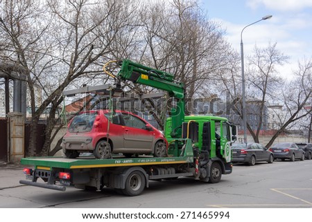 MOSCOW, RUSSIA - APRIL 21: An authorised removal unit lifts up and removes an illegaly parked car on April 21, 2015 in Moscow, Russia.