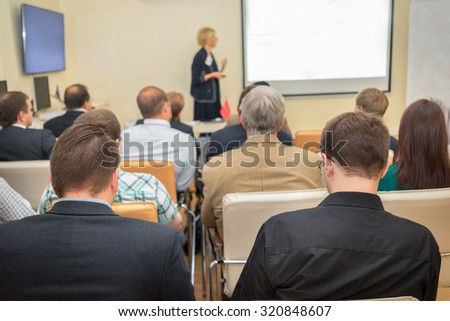 Female academic professor lecturing at faculty. Students at the lecture hall.