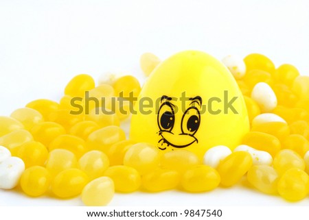 Yellow smiley fact with yellow and white jelly bean on white background
