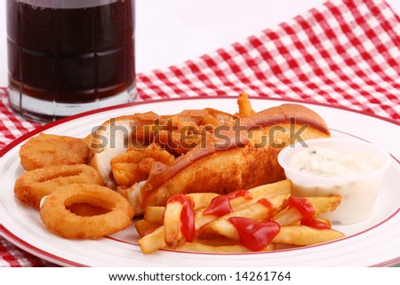 clam roll, french fries and onion rings on a plate with soda in the background
