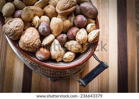 Almonds and other nuts in a neat metal and ceramic serving dish
