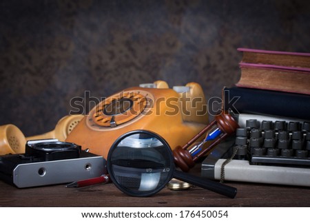 Group of objects on wood table. magnifying glass, old telephone, type writer, old camera, Still life