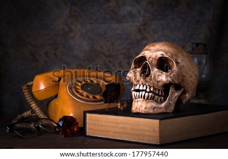 Group of objects on wood table. old book, human skull ,old rusty kerosene lamp,old telephone, Still life