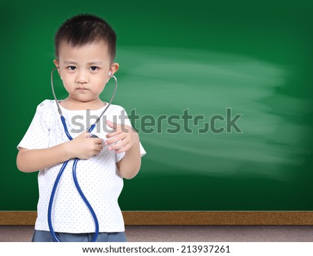 Little asia boy holding stethoscope with green chalk board
