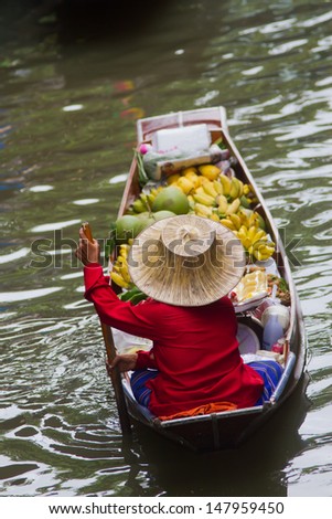 A woman selling fruits at Bangkok floating market.