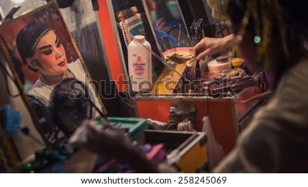 TALAD-NOI, THAILAND - OCT 01, 2014: A Chinese Opera actress applies makeup backstage before her show at the TALAD-NOI vegetarian cafeteria celebrating the Nine Emperor Gods Festival in Thailand.