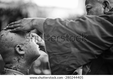 NONTHABURI, THAILAND - MAY 03 : Thai man gets his head shaved by a monk with intend during a Buddhist ordination ceremony on May 03, 2015 in Nonthaburi, Thailand. black and white tone
