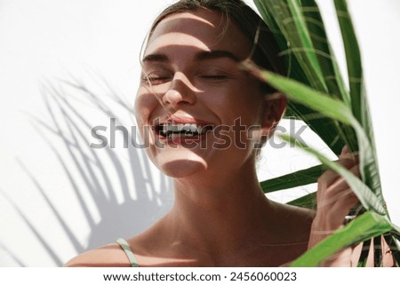 Similar – Image, Stock Photo Model with leaf shadows on face in light ray