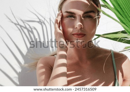 Similar – Image, Stock Photo Model with leaf shadows on face in light ray