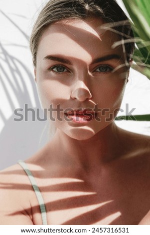 Similar – Image, Stock Photo Model with leaf shadows on face in light ray