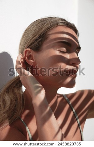 Similar – Image, Stock Photo Model with leaf shadows on face in light ray