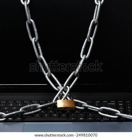 Padlock and chain on a laptop keyboard. Concept of internet security