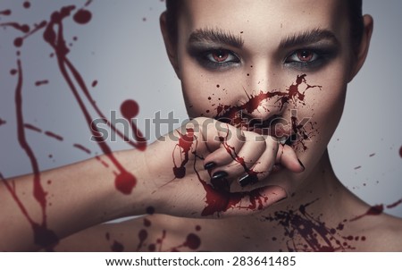 Sexy vampire woman with blood on her face