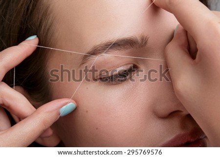 Close-up of female face during eyebrow correction procedure