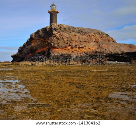 Tip of Jandia in low tide with stone lighthouse on the crag, coast of Fuerteventura, Canary islands, Spain