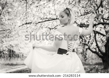 Portrait of beautiful woman in blooming tree in spring. Girl enjoying nature. Garden, beauty, trees, - concept of enjoying nature. Idea of  the article about the garden and nature.