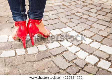 woman legs in red high heel shoes outdoor shot on cobble street