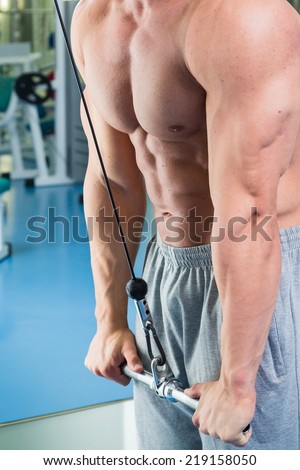 Man with weight training equipment on sport gym club.Man makes exercises. Sport, power, dumbbells, tension, exercise - the concept of a healthy lifestyle. Article about fitness and sports.
