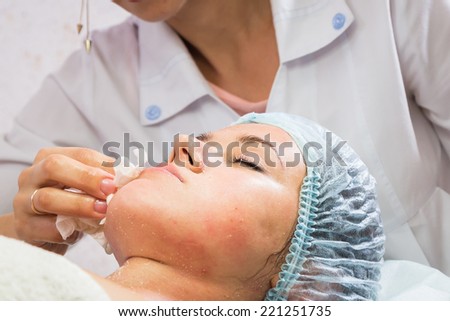 Beautiful woman with facial mask at beauty salon.Pretty woman receiving facial massage.Spa therapy for young woman receiving facial mask at beauty salon - indoors