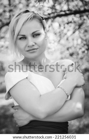 Beautiful happy brunette woman in the park on a warm summer day.Portrait of young lovely woman in spring flowers.Beautiful spring girl in blooming tree.Beautiful woman with white flowering tree